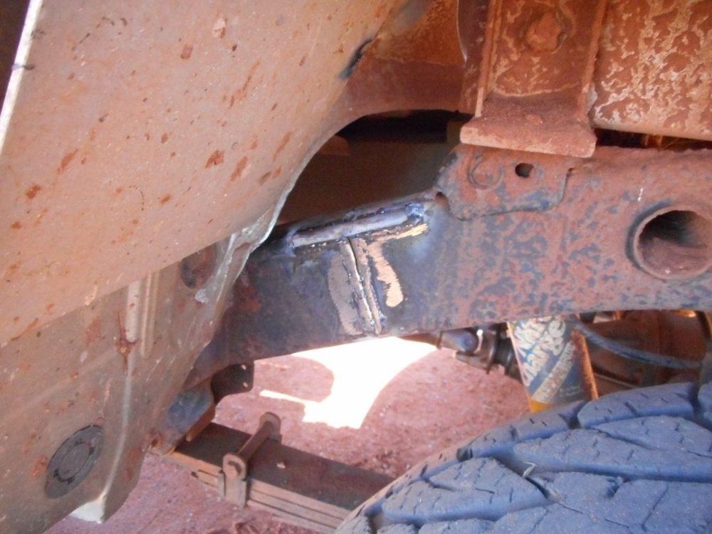 Welded repair on a rusty ute chassis rail viewed from underneath