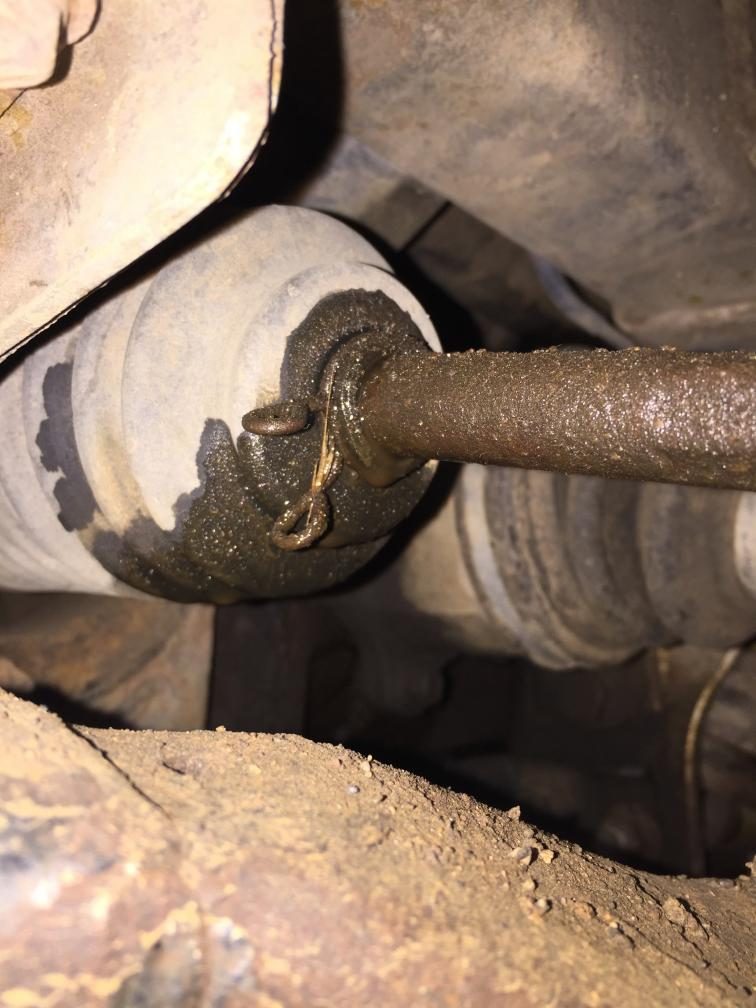 Steering rack boot and shaft with oily residue underneath a Toyota Hilux