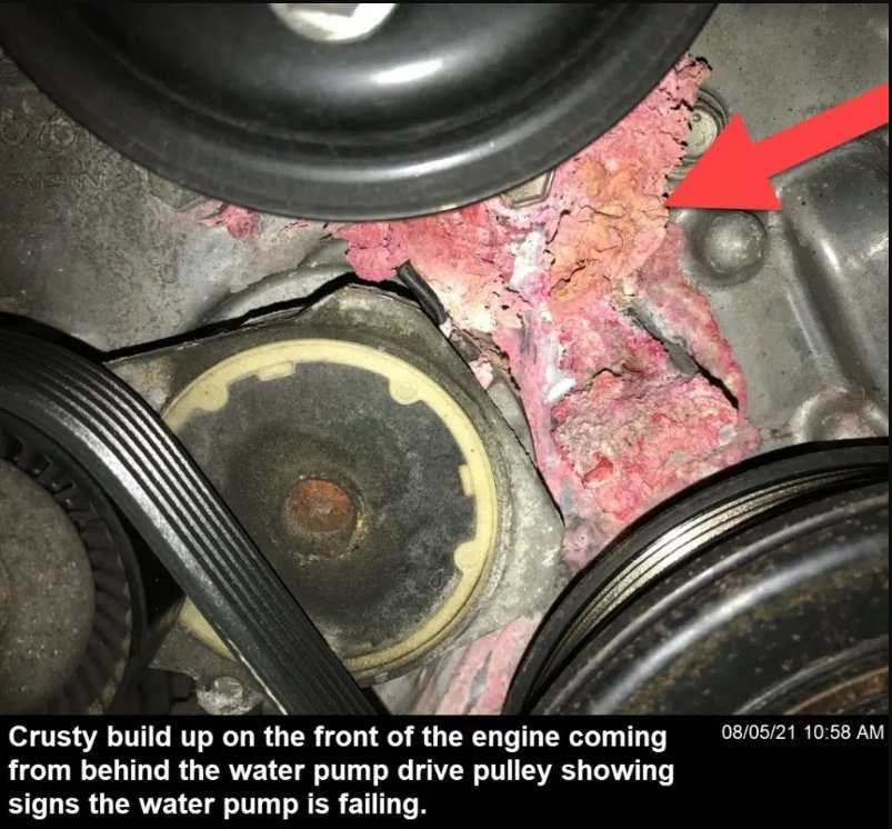 Crusty pink coolant build-up behind the water pump pulley on a Toyota engine